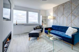 a living room with a blue couch and a chair at Modern Place Apartament przy plaży in Gdynia