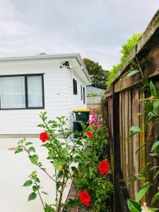 a fence and flowers in front of a house at New Smart Home Nearby Plaza in Auckland
