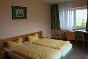 a bedroom with a bed and a desk and a window at Hotel "An der Warthe" in Salzwedel
