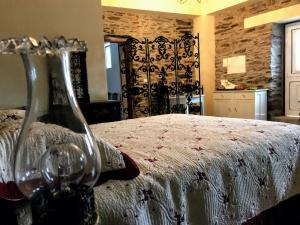 a bedroom with a bed with two wine glasses at Casa da Escola Antiga in Manteigas