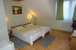 a bedroom with two beds in a room at Koller Panzió in Bonyhád