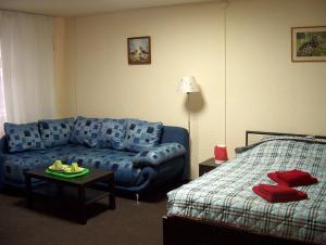 a living room with a couch and a bed at Hotel Four Rooms in Tyumen