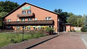 un edificio de hotel con sombrillas delante en Hotel "An der Warthe", en Salzwedel