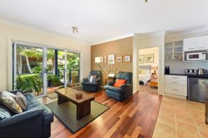 uma sala de estar com um sofá e uma mesa em Azura Beach House B&B em Port Macquarie