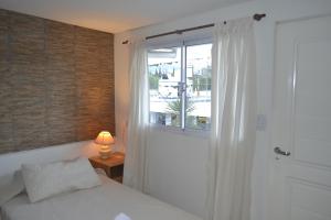 a bedroom with a bed and a window and a lamp at Guest House Jujuy in San Salvador de Jujuy