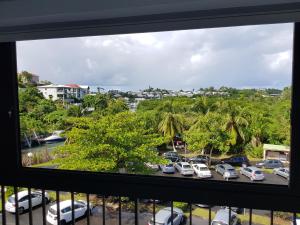 a view from a window of a parking lot at Joli T2 à 5 min de la plage in Le Gosier +3 photos