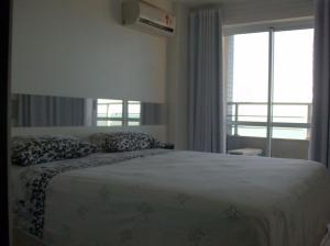 Un dormitorio con una cama grande y una ventana en Varandas de Iracema 1102, en Fortaleza