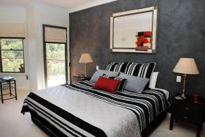 
a bedroom with a large bed and a large window at Wombadah Luxury Accommodation in Buckaroo
