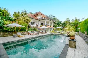 a house with a swimming pool in front of a house at Bukit Asri Lodge in Seraya