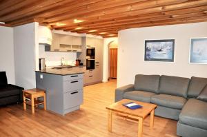 a living room with a couch and a kitchen at Chasa Sager 4 in Scuol