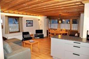 a kitchen and living room with a couch and a table at Chasa Sager 4 in Scuol