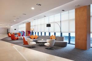 a lobby with a couch and chairs and a table at Howard Johnson by Wyndham Incheon Airport in Incheon