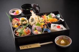 a box filled with different types of food on a table at Sky Hotel Namerikawa in Namerikawa