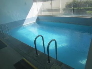 una piscina con dos barras de metal. en Depto Marina Poniente, en Viña del Mar