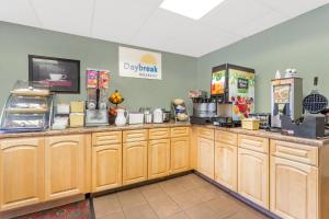 a kitchen with wooden cabinets and a counter top at Days Inn by Wyndham Cedar Falls- University Plaza in Cedar Falls