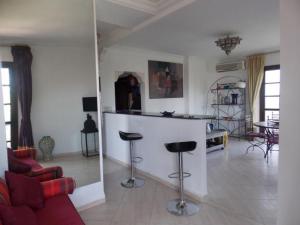 - un salon avec un bar au milieu d'une pièce dans l'établissement Appart avec vue Jardin/Majorelle, à Marrakech