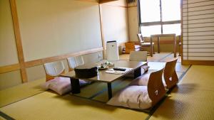 Habitación con mesa, sillas y mesa. en Yuttarino-Sato Inaka en Achi