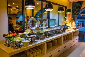 a buffet line with food on display in a restaurant at Ritzy Boutique Hotel Da Nang Beach in Da Nang