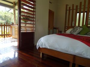 Schlafzimmer mit einem Bett und Holzboden in der Unterkunft Sweetwater Lodge in Julatten