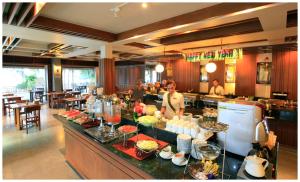 a man standing at a buffet in a restaurant at Maehaad Bay Resort - SHA Plus in Mae Haad