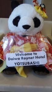 un oso panda de peluche usando un vestido y una señal en Daiwa Roynet Hotel Osaka Yotsubashi, en Osaka