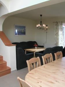 a dining and living room with a table and chairs at Gólya Villa Park in Velence