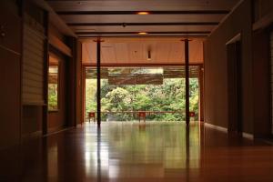 an empty room with a large glass door with a balcony at Saryo Souen in Sendai