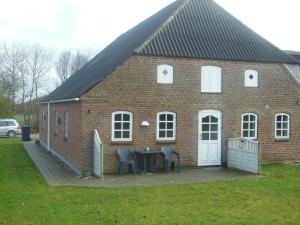 a brick building with a white door and a black and white checkered at Holmsland Bed & Breakfast in Ringkøbing