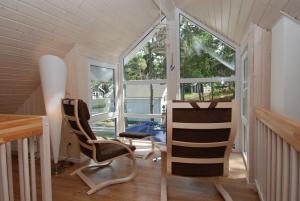 a room with two chairs and a table and windows at Strandpark Baabe Haus 224 in Baabe