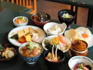 einen Tisch mit Schalen verschiedener Arten von Lebensmitteln in der Unterkunft APA Hotel Kanazawa-nishi in Kanazawa