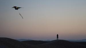 una persona che vola un aquilone in cima a una collina di Desert Days mud cabin's Resort a Zuqim