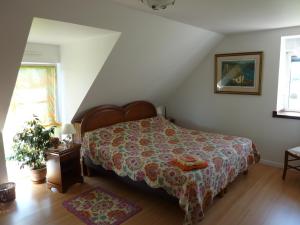 ein Schlafzimmer mit einem Bett, auf dem eine Bettdecke liegt in der Unterkunft Ti Er Mad in Kernascléden