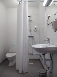 a bathroom with a toilet and a shower curtain at Hotel Åberg Centralhotellet in Tranås