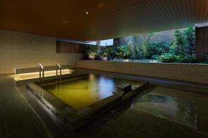 a bath room with a pool in the middle of it at Mitsui Garden Hotel Kashiwa-No-Ha in Kashiwa