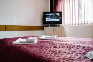 Un dormitorio con una cama roja con toallas. en Pensiunea Georgibel en Deva