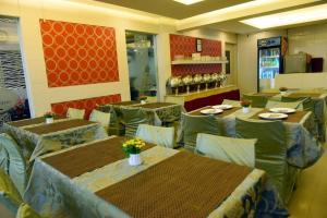a restaurant with tables and chairs in a room at Hotel Pearl International in Chennai