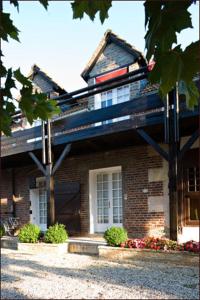 uma casa de tijolos com um telhado de gambrel em Auberge A La Bonne Idée em Saint-Jean-aux-Bois