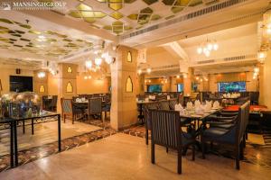 a restaurant with tables and chairs in a room at Mansingh Palace, Agra in Agra