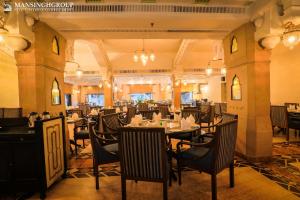 a restaurant with tables and chairs in a room at Mansingh Palace, Agra in Agra