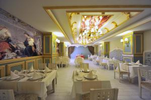 Seaden Corolla Hotel All Inclusive في سيدي: مطعم بطاولات وكراسي و لوحة على الحائط