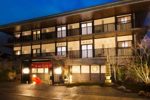 a large building with a balcony on the side of it at Ryokan KANADE in Kyoto