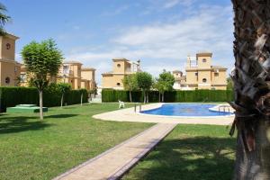 a yard with a swimming pool in front of a house at villa las tres perlas in Algorfa