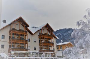 a large building with snow covered mountains in the background at Residence Erika in Siusi