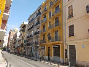 バレンシアにあるGuillem Sorolla Apartmentの通路脇の黄色い建物