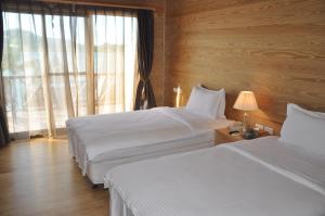 コロールにあるアイランド パラダイス リゾート クラブのベッド2台と窓が備わるホテルルームです。