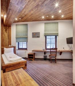 a bedroom with a bed and a desk in it at Shpatser hotel in Briukhovychi