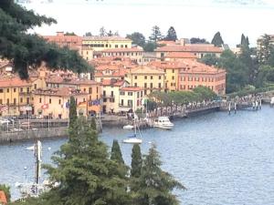 a view of a city with a river with boats at Hotel Du Lac Menaggio in Menaggio