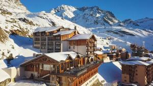 a resort in the snow with mountains in the background at Hôtel Koh-I Nor by Les Etincelles in Val Thorens