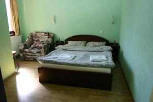 1 dormitorio con 1 cama grande y 1 silla en Family Hotel Studio en Sandanski