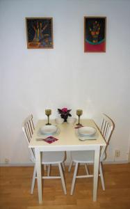 a white table with chairs and plates and flowers on it at Studio in Helsinki city center in Helsinki